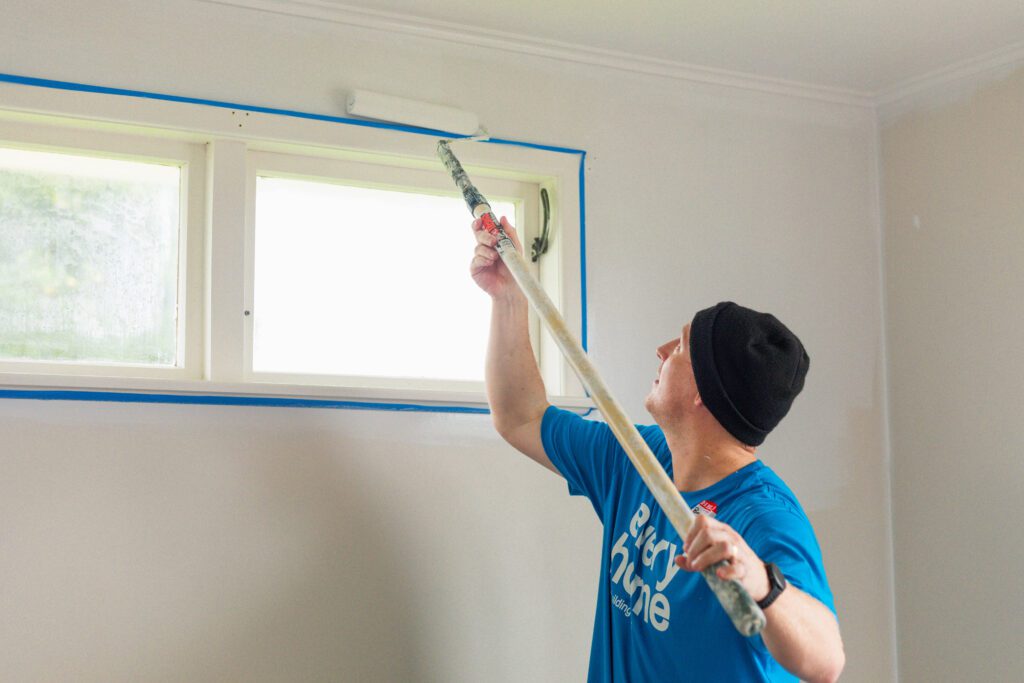 PinkFit® team member priming the bedroom walls during a volunteer day with Habitat for Humanity New Zealand.  